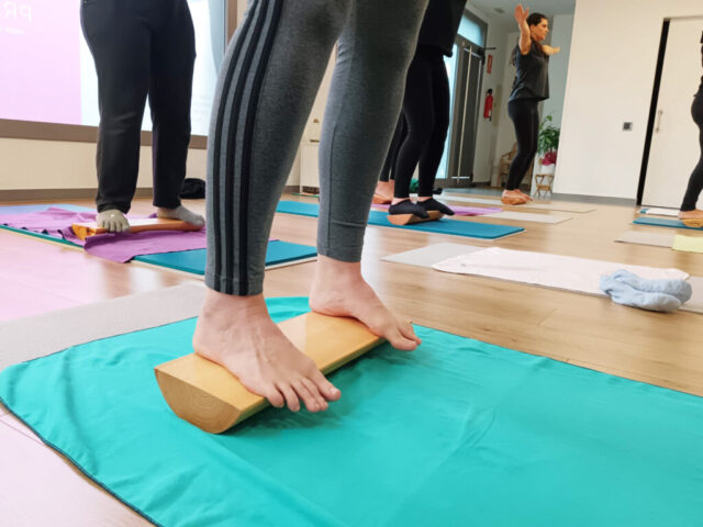 Primer pla de peus sobre una cunya de fusta en una sessió d’alineació.